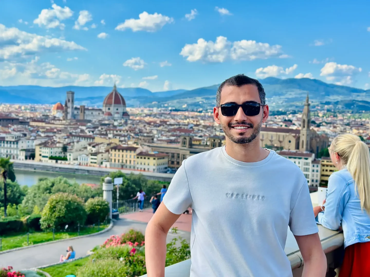 Emir Balın in front of the Florence skyline from Piazzale Michelangelo, with the Florence Cathedral (Duomo) visible